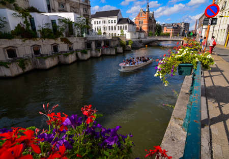 Ghent, Belgium, August 2019.The canals are crossed by tourist boats: they give a particular point of view to visit the city. The planters along the banks color the scene pleasantly. Sweet day.のeditorial素材