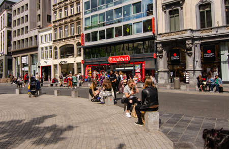 Antwerp, Flanders, Belgium. August 2019. Along the main shopping street, the meir, many people stroll around the city. A group of girls are making a stop by sitting down.のeditorial素材