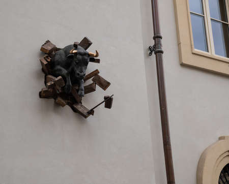 Turin, Piedmont, Italy. May 2020. A bull breaks through a wall with its golden horns: an artistic installation dedicated to the city and its revival. Titled T'oro for golden horns.のeditorial素材