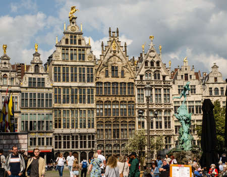 Antwerp, Flanders, Belgium. August 2019. On a beautiful sunny day the facades of the guild houses in the town hall square spice for beauty. People enjoy the beautiful day.のeditorial素材