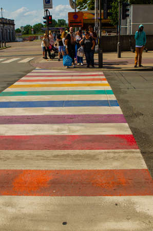 Antwerp, Flanders, Belgium. August 2019. Characteristic rainbow pedestrian crossings: with their bright colors they stand out immediately. Pedestrians are preparing to cross.のeditorial素材