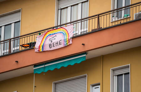 Turin, Piedmont, Italy. May 2020. Coronavirus pandemic. On the facades of the houses hang the sheets with the drawing of the rainbow and message everything will be fine. In Italian "AndrÃ  tutto bene"のeditorial素材