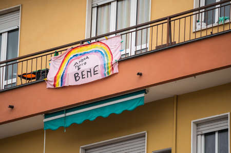 Turin, Piedmont, Italy. May 2020. Coronavirus pandemic. On the facades of the houses hang the sheets with the drawing of the rainbow and message everything will be fine. In Italian "AndrÃ  tutto bene"のeditorial素材