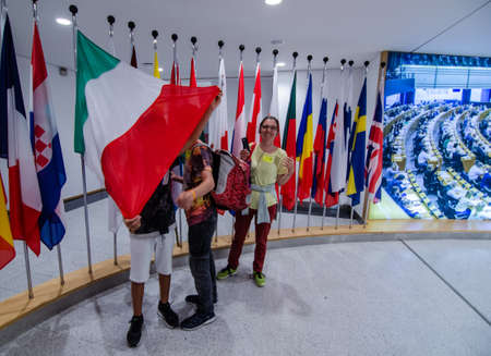 Brussels, Belgium, August 2019. At the headquarters of the European Parliament: the flags of the member states. An Italian mom with her children play with the Italian flag.のeditorial素材