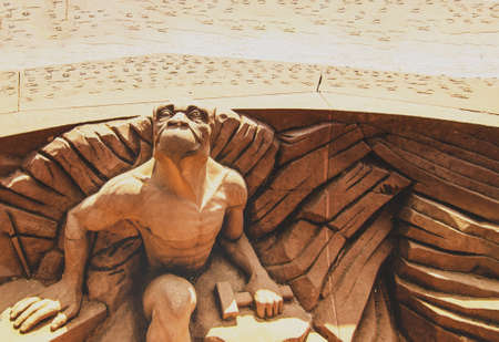 Strasbourg, France, August 2019. A gargoyle placed on the square surrounding the cathedral looks with satisfaction at the Gothic building. He has a hammer in one hand.のeditorial素材