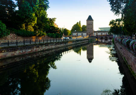 Strasbourg, France, August 2019. The historic center offers the view of pleasant and relaxing views: at dusk one of the towers of the covered bridges is reflected on the canal.のeditorial素材