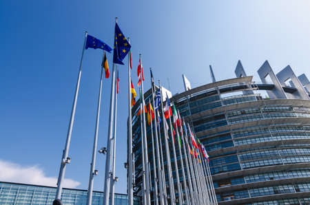 Strasbourg, France. August 2019.The entrance to the modern seat of the European parliament. A row of flagpoles with the flags of the member states of the European Union welcomes those who enter.のeditorial素材