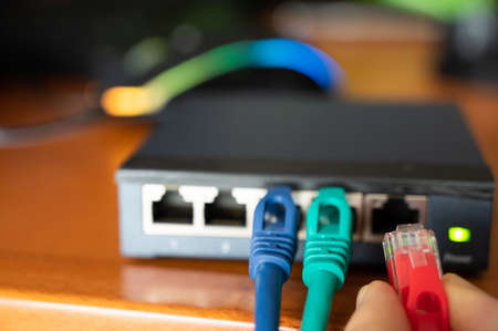 Close-up image of a router:  connections of  three red, green cables are tested. Concept of cabling,...