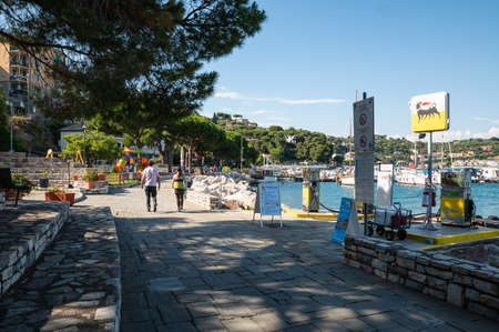 Portovenere, Liguria, Italy. June 2020. View of the seascape: on the waterfront a petrol station, moored boats, the green hills surrounding the bay.のeditorial素材