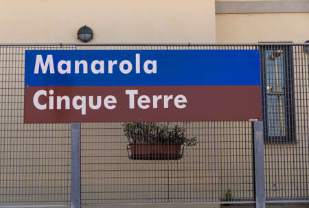 Manarola, Liguria, Italy. June 2020. The blue sign with white writing together with the brown tourist information sign at the train station. Famous tourist destination.のeditorial素材