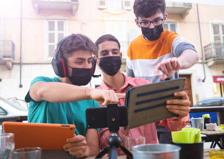 A group of friends is making a live broadcast  from the tables of an outdoor pub.  Concept of new...