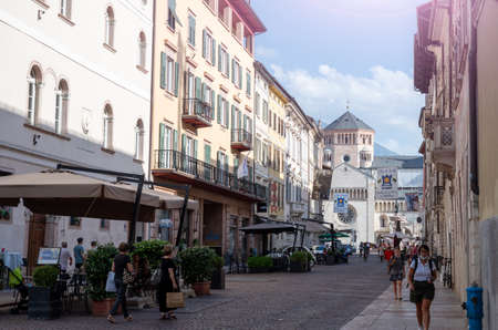 Trento, Italy, June 2021. Beautiful view of one of the streets of the historic center that goes to the cathedral square: in the background you can recognize the fonatana di neptune. People on the street.のeditorial素材