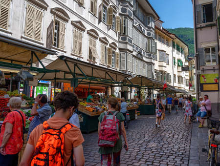Bolzano, Italy, June 2021. At the local market, people walk among the stalls looking at the goods....