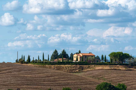 Tuscany, Italy. August 2020. Amazing landscape of the Tuscan countryside with the typical rolling hills and cypresses to mark the boundaries. In evidence the farm.のeditorial素材