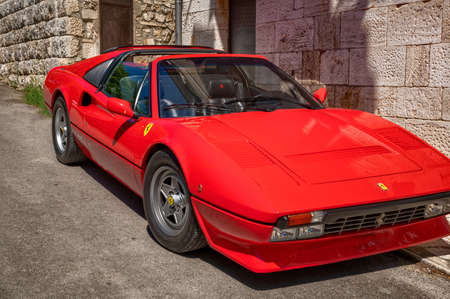Bagno Vignoni, Tuscany, Italy. August 2020. A splendid bright red Ferrari, an icon of the 80s. Tilt footage, beautiful sunny day.のeditorial素材