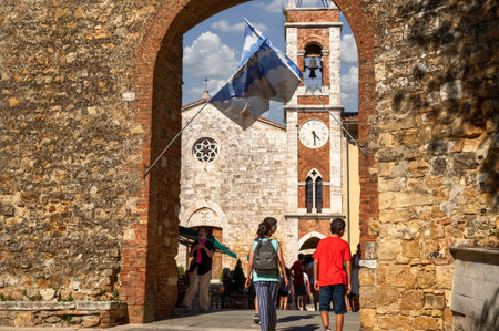 San Quirico d'Orcia, Tuscany, Italy. August 2020. One of the access doors in the walls of the historic village. People and the bell tower in the background. Beautiful summer dayのeditorial素材