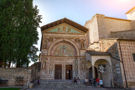 Perugia, Umbria, Italy. August 2021. Church of San Francesco al Prato, detail of the finely decorated portal. People gather on the lawn and stop for a break.のeditorial素材