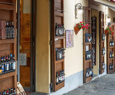 Montalcino, Tuscany, Italy. August 2020. The typical local wine shops overlook the main street of the village, primarily the Brunello. The bottles are also displayed outside the shop.のeditorial素材