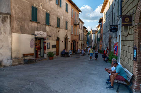 Montalcino, Tuscany, Italy. August 2020. The typical local wine shops overlook the main street of the village, people walk through it. Some are seated at tables in a winery.のeditorial素材