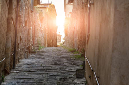 Montalcino, Tuscany, Italy. August 2020. A picturesque and charming alley in the historic center. The medieval style stone pavement. Nobody.の写真素材
