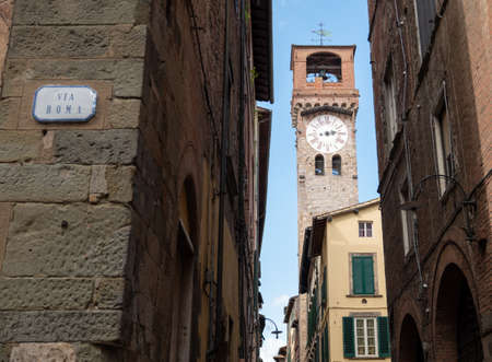 Lucca, Tuscany, Italy. August 2020. Pleasant view of the clock tower, made of red bricks, in the historic center. Beautiful summer day.の写真素材