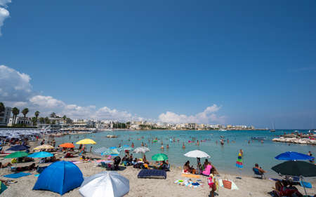 Otranto, Puglia, Italy. August 2021. Amazing view of the waterfront, people stop along the wall to enjoy the view. Beautiful summer day.の写真素材