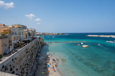 Otranto, Puglia, Italy. August 2021. Amazing view from the top of a panoramic point on the village: the gaze passes from the town to the sea and the marinaの写真素材