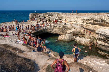 Roca Vecchia, Melendugno, Puglia Italy. August 2021. Footage of the Grotta della Poesia, an amazing natural pool connected to the open sea. People enjoy the heavenly place by diving.のeditorial素材