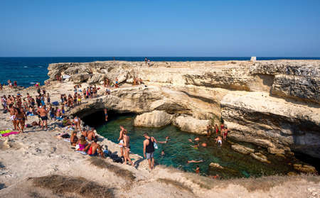 Roca Vecchia, Melendugno, Puglia Italy. August 2021. Footage of the Grotta della Poesia, an amazing natural pool connected to the open sea. People enjoy the heavenly place by diving.のeditorial素材