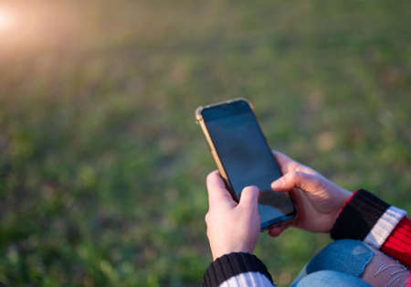 Close up shot on the smartphone screen as a young woman's fingers are typing messages. Copy space.の写真素材