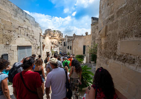 Matera, Basilicata, Italy. August 2021. Splendid view with the rock church of Santa Maria of Idris in the Upper Left. Urban Landscape of the Stones of Matera. Crowd of People Visiting the Old Town.のeditorial素材