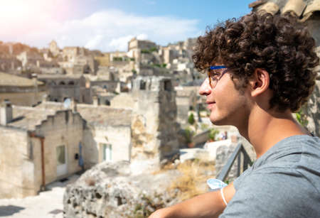 Matera, Basilicata, Italy. August 2021. A young tourist is looking at the amazing old town....