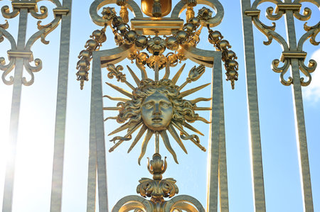 Versailles, Paris, France, June 30, 2022. Gorgeous detail of the golden gate of the royal palace. The late afternoon light enhances its brilliance.の写真素材