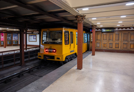 Budapest, Hungary, August 30, 2022. Old metro M1 stop. The yellow train is moving away from the platform. Vintage lines and style perfectly preserved.の写真素材