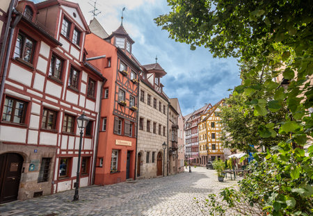 Nuremberg, Germany, 1 August 2023. The tanners' street: it has all the charm of the ancient city with the facades of the colorful and half-timbered houses. People walk along the stone-lined street.の写真素材
