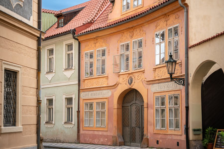 Prague, Czech Republic, August 6, 2023. A charming glimpse of the Old Town, with the street curving and hiding among the colorful houses. The vintage sign of a cafÃ©-restaurant. Visiting Prague.の写真素材