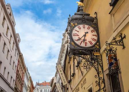Prague, Czech Republic, August 7, 2023. A shot of the entrance to the U Fleku brewery, the oldest and most famous in the city. The beautiful vintage street clock is prominent. Travel destinations.の写真素材