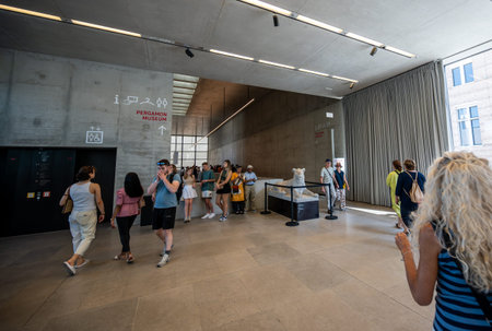 Berlin, germany, august 15, 2023. Museum guests exploring the modern architecture of the james simon gallery lobby, viewing a lion sculpture and directional signsのeditorial素材