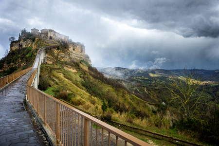 Civita di Bagnoregio, Viterbo, Lazio, Italy: picturesque landscape of the ancient village shrouded in fog on the steep tuff hillの写真素材