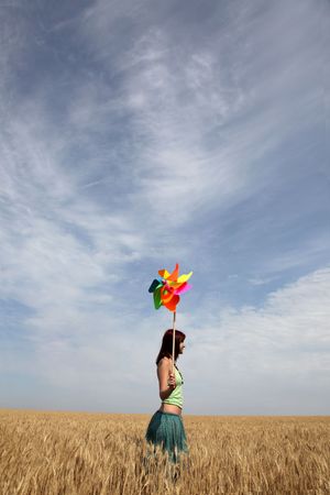 Girl with wind turbine at wheat fieldの写真素材