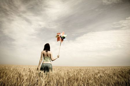 Girl with wind turbine at wheat fieldの写真素材