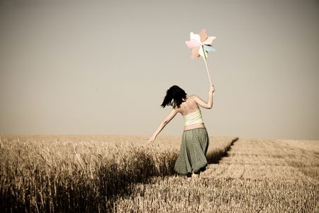 Girl with toy wind turbine at fieldの写真素材