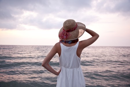 Young beautiful girl on the beach at sunriseの写真素材