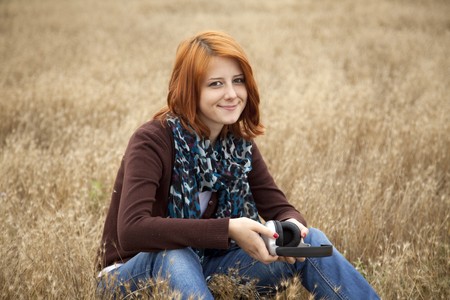 Young  smiling girl with headphones at field.の写真素材