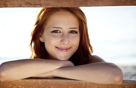 Portrait of beautiful red-haired girl near wood.の写真素材