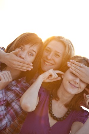 Portrait of three beautiful girls. With counter light on background.の写真素材