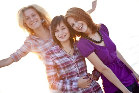 Portrait of three beautiful girls. With counter light on background.の写真素材