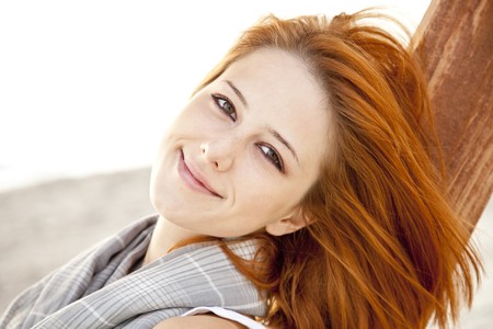 Young red-haired girl at wood near sea.の写真素材