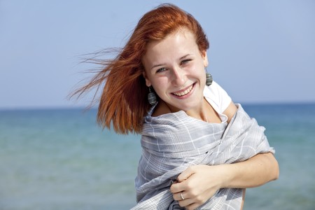 Young red-haired girl on the beachの写真素材