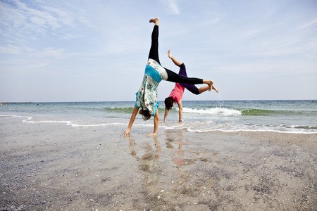 Young girl show an acrobatic on the beach.の写真素材